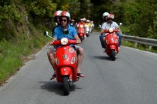 The team rides on Vespas through Liguria