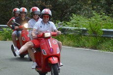 Die Teilnehmer genießen die Fahrt mit der Vespa im warmen Italien